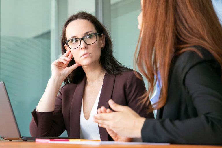 woman looking at workmate talking - one-on-one meeting mistakes
